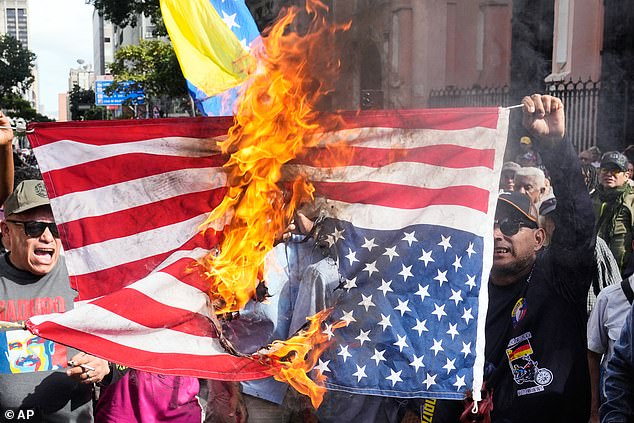 Government supporters burn a U.S. flag in Caracas, Venezuela, Saturday