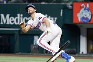 Texas Rangers batter Josh Smith watches his  fifth inning bunt shoot high in the air and...