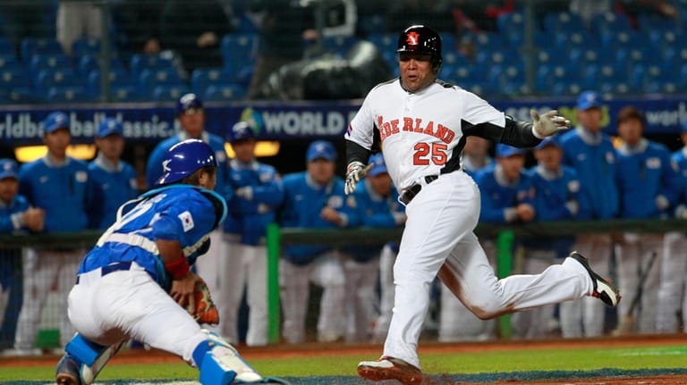 The Netherlands' designated hitter Andruw Jones (25) tries to dodge...