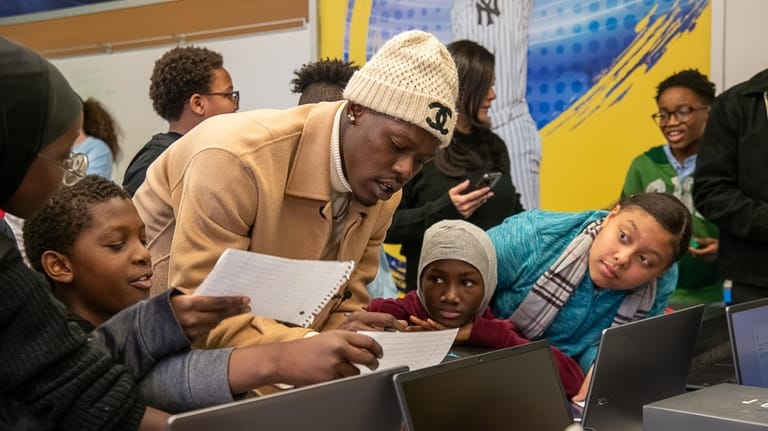 Yankees second baseman Jazz Chisholm Jr. signs autographs for the students...