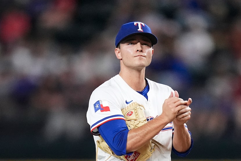 Texas Rangers starting pitcher Jack Leiter rubs a new ball after a home run by Arizona...