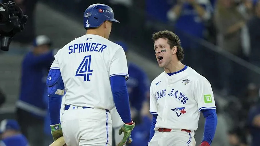 Toronto Blue Jays third baseman Ernie Clement celebrates with right fielder George Springer.