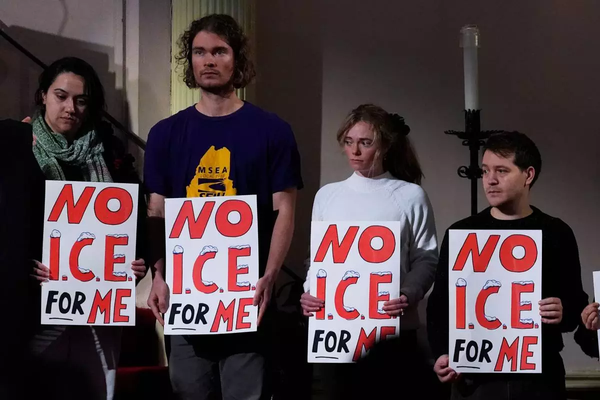Attendees hold signs at a news conference held by public officials and faith leaders calling for the abolishment of the U.S. Immigrant and Customs Enforcement, Friday, Jan. 30, 2026, in Portland, Maine. (AP Photo/Robert F. Bukaty)