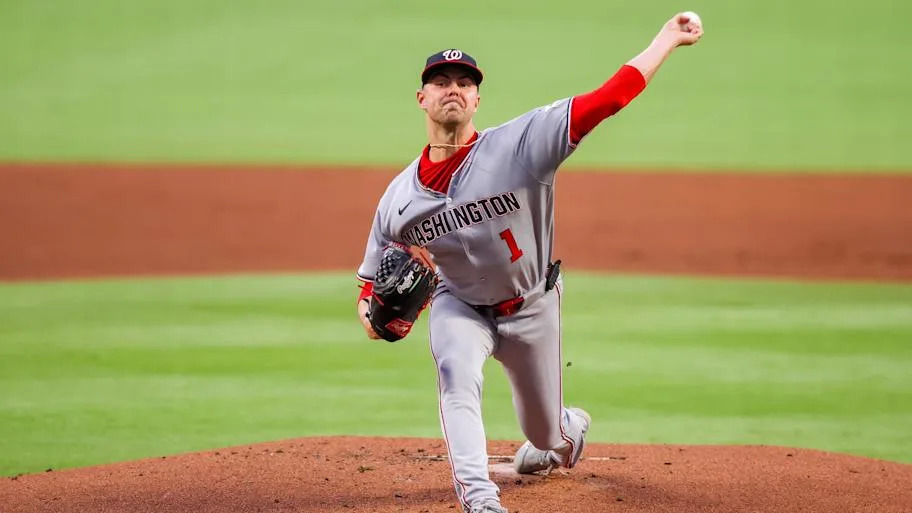A baseball player in a white uniforms that says