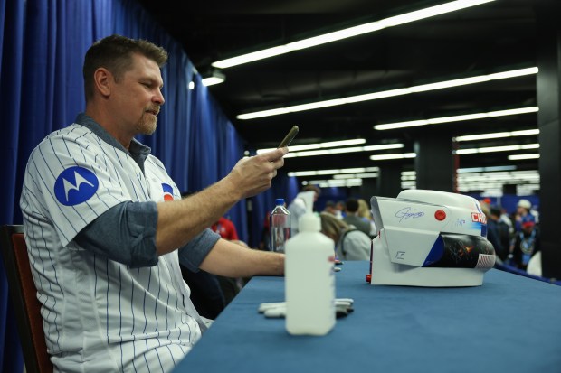 Former Cubs pitcher Kerry Wood takes a picture of a helmet after signing it during the Cubs Convention at the Sheraton Grand Chicago Riverwalk on Jan. 17, 2025. (John J. Kim/Chicago Tribune)