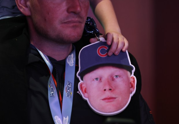 A child holds a cutout of Cubs player Pete Crow-Armstrong while sitting on a grown up's shoulders during the Cubs Convention at the Sheraton Grand Chicago Riverwalk on Jan. 17, 2025. (John J. Kim/Chicago Tribune)