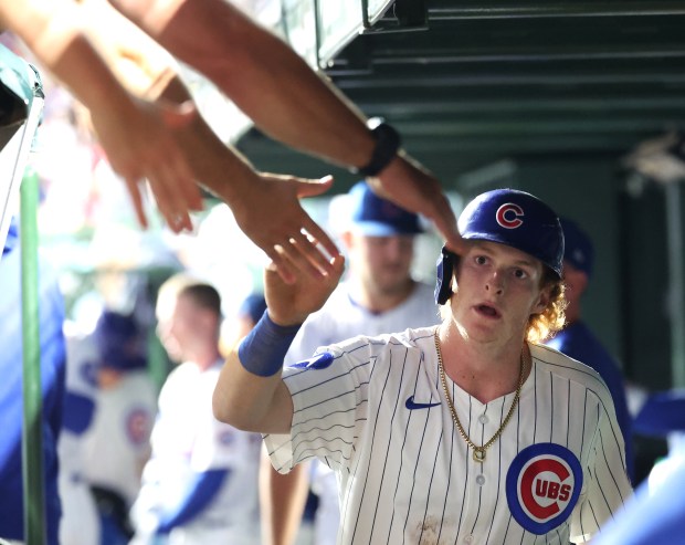 Chicago Cubs right fielder Owen Caissie is congratulated in the dugout after scoring on a double by teammate Michael Busch in the second inning of game 2 of a doubleheader against the Milwaukee Brewers at Wrigley Field in Chicago on Aug. 19, 2025. (Chris Sweda/Chicago Tribune)