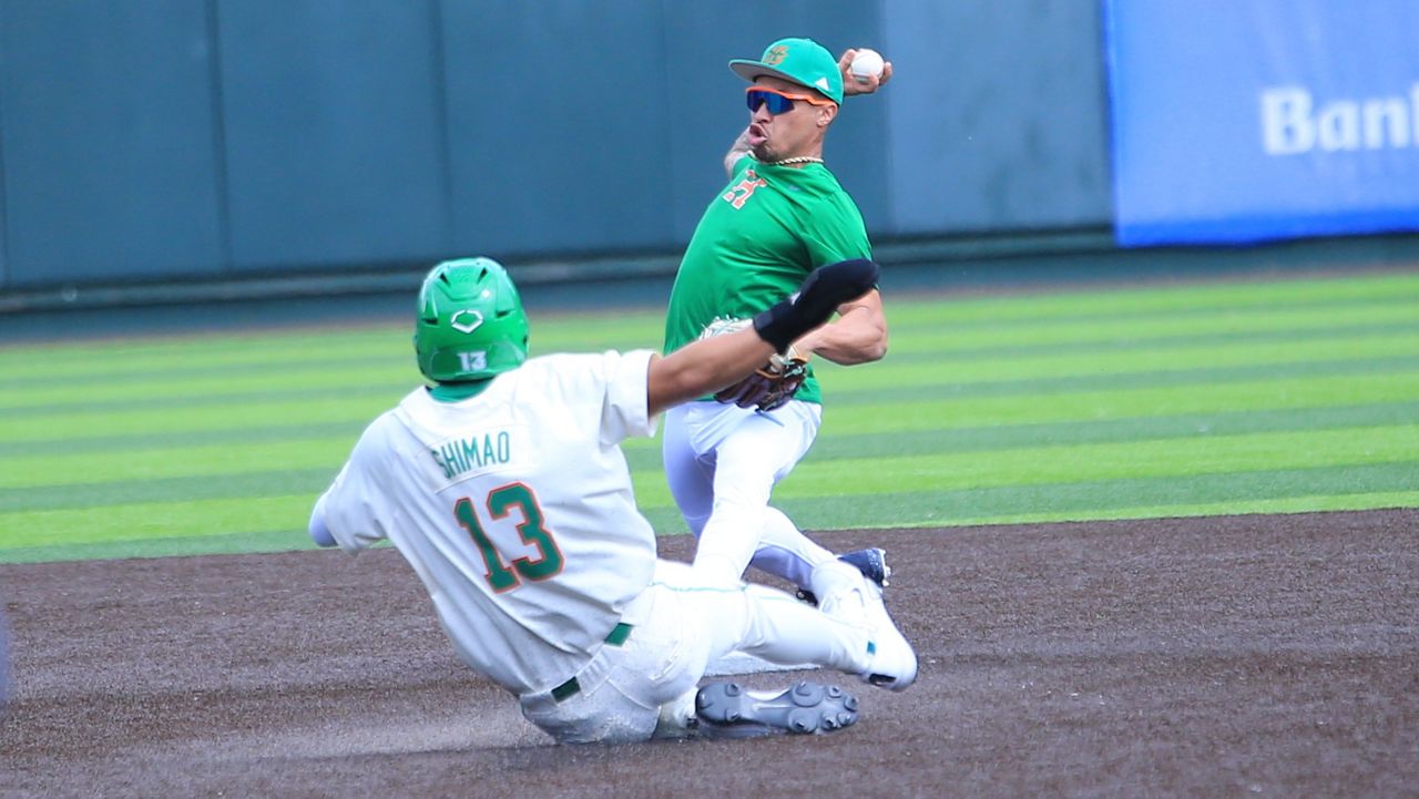 Hawaii baseball great Kolten Wong turned a double play at second base in the UH alumni game on Saturday, tagging second ahead of the slide by Tate Shimao and throwing to first for the second out.