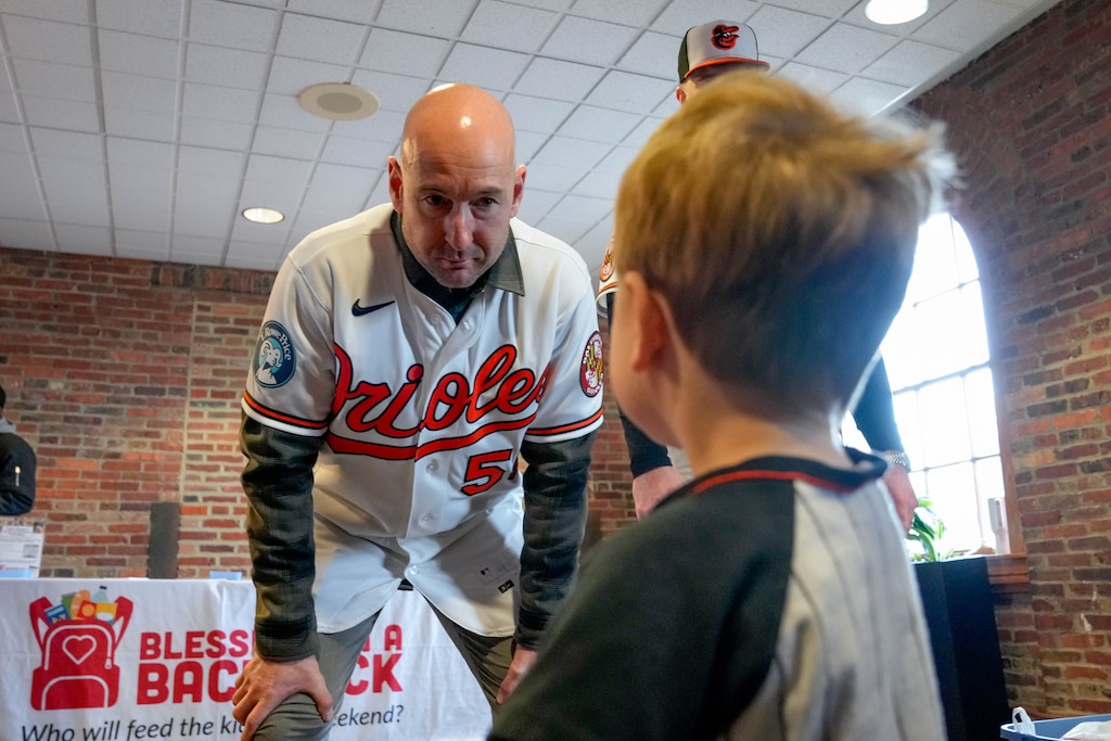 Baltimore Orioles manager Craig Albernaz bends down to speak with Ian Gayfield, 2, during a Birdland Caravan event in the warehouse at Oriole Park at Camden Yards in Baltimore, Md., on Friday, January 23, 2026.