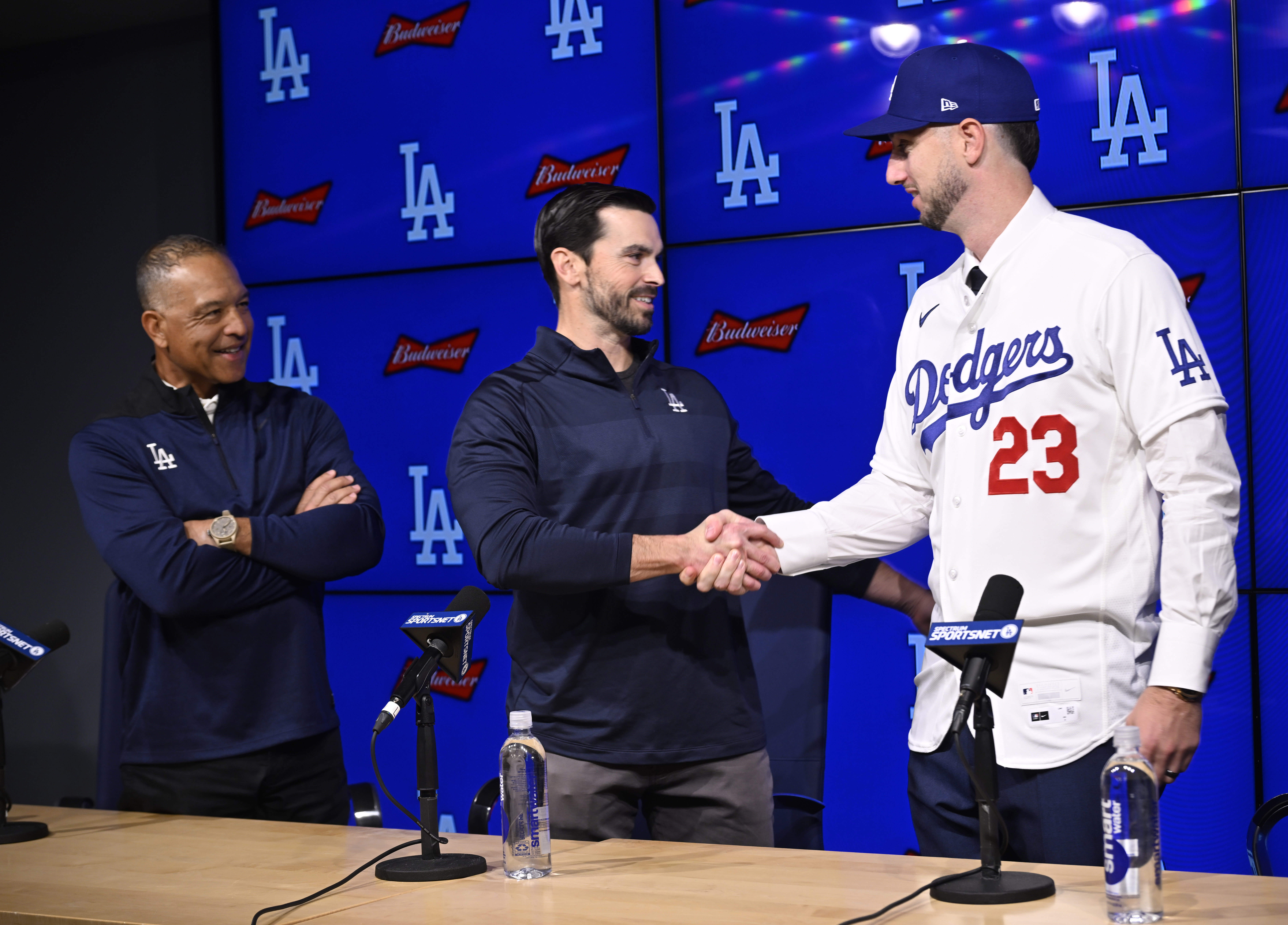 Dodgers general manager Brandon Gomes, center, shakes hands with newly...
