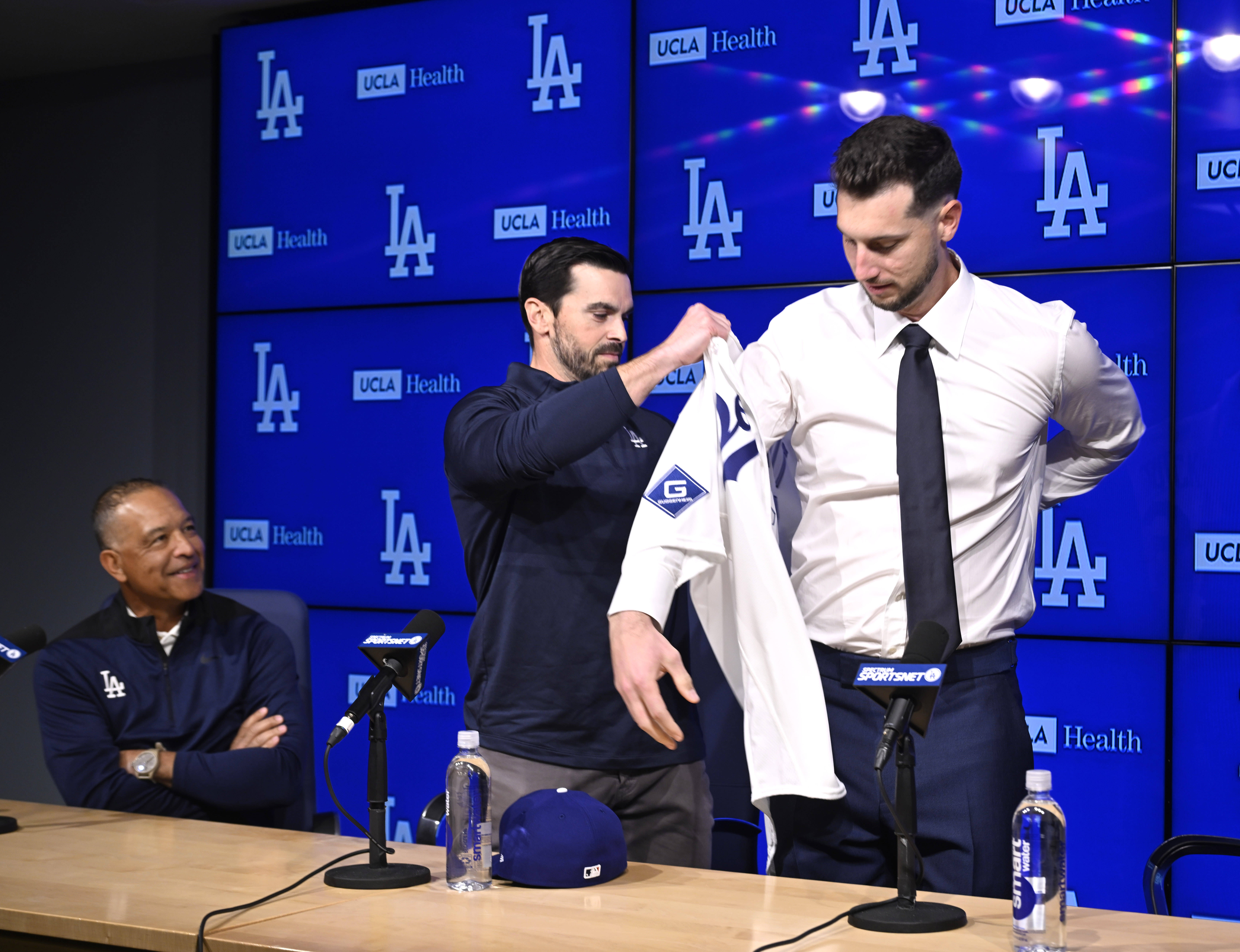 Dodgers general manager Brandon Gomes, center, helps newly signed outfielder...
