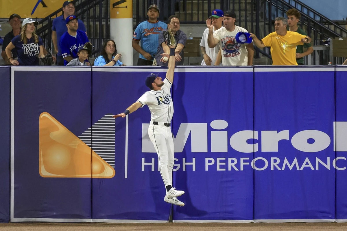 Tampa Bay Rays outfielder Josh Lowe jumps for a hit by Toronto Blue Jays' Nathan Lukes that was eventually ruled a home run after review during the fourth inning of a baseball game Tuesday, Sept. 16, 2025, in Tampa, Fla. (AP Photo/Mike Carlson)