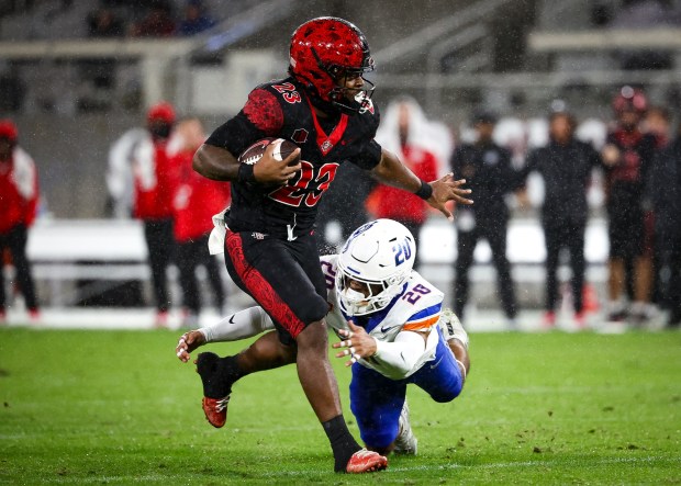 Christian Washington #23 of the San Diego State Aztecs runs the ball against Jaden Mickey #20 of the Boise State Broncos during their game at Snapdragon Stadium on Saturday, Nov. 15, 2025 in San Diego, California. (Meg McLaughlin / The San Diego Union-Tribune)