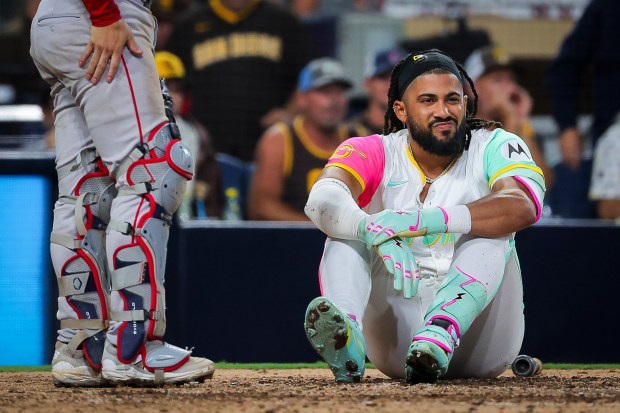 Fernando Tatis Jr. #23 of the San Diego Padres sits on the ground after evading being hit by a pitch during the eighth inning against the Boston Red Sox at Petco Park on Friday, Aug. 8, 2025 in San Diego, CA.