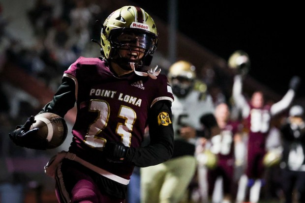 Point Loma's Chase Thomas (23) smiles as he runs the ball in for a touchdown against Mater Dei during CIF San Diego Section Division 1 football playoff game at Point Loma High School on Friday, Nov. 7, 2025 in San Diego, California. (Meg McLaughlin / The San Diego Union-Tribune)