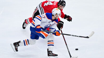 Feb 5, 2025; Chicago, Illinois, USA; Edmonton Oilers center Connor McDavid (97) and Chicago Blackhawks left wing Landon Slaggert (84) battle for the puck during the third period at the United Center. Mandatory Credit: Daniel Bartel-Imagn Images