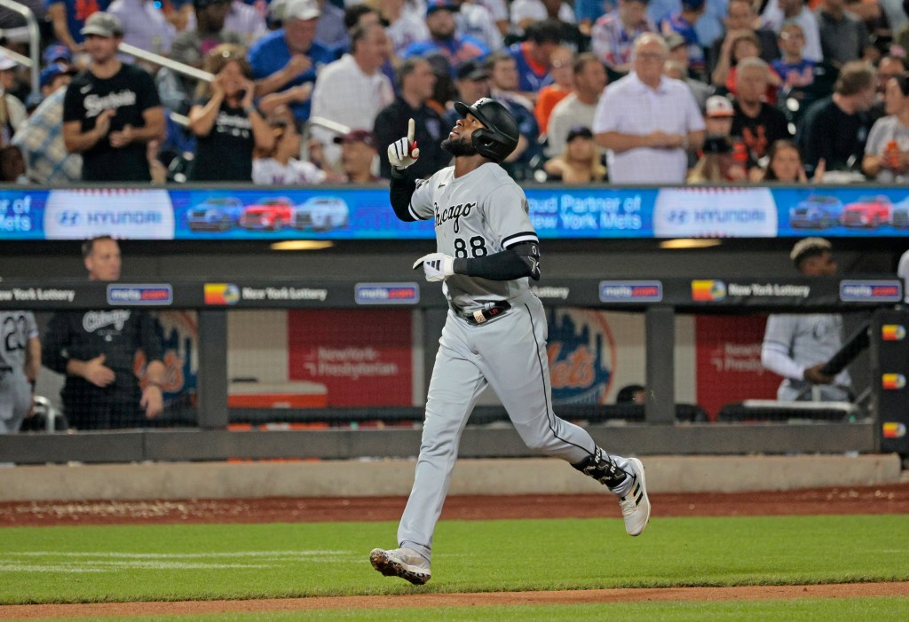 Chicago White Sox center fielder Luis Robert Jr. pointing upward after hitting a solo home run.