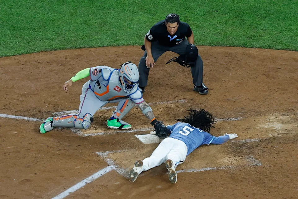 Washington Nationals shortstop CJ Abrams (5) crosses home plate ahead of a tag by New York Mets catcher Francisco Alvarez (4) to score the game winning run on an RBI single by Nationals outfielder James Wood (not pictured) during the ninth inning on April 25, 2025, at Nationals Park.