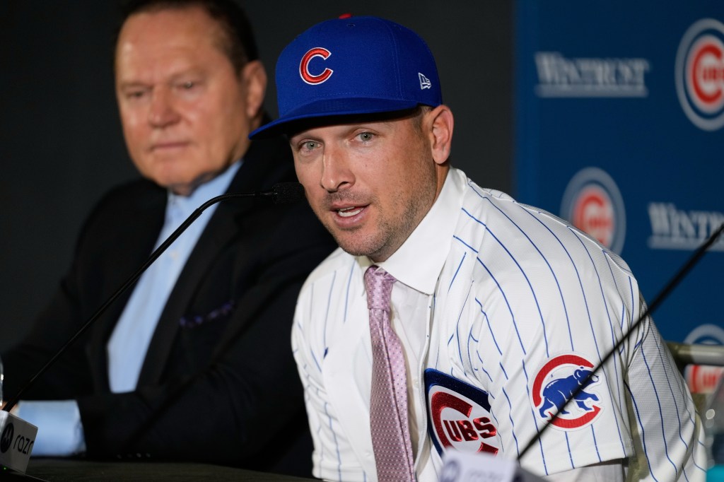 Alex Bregman in a Chicago Cubs jersey and hat speaking at a news conference.
