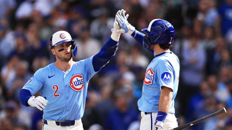 Chicago Cubs infielders Nico Hoerner and Dansby Swanson celebrate at home plate in a game against the Washington Nationals at Wrigley Field.