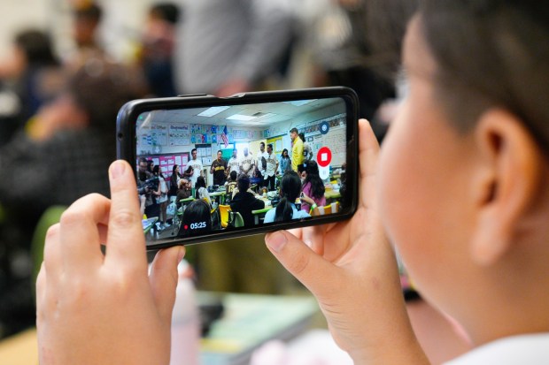 A student from Smythe Elementary School used his smartphone to videotape the visit of a few of the Padres players to their classroom on Friday, Jan. 30, 2026, in San Diego, CA.  (Nelvin C. Cepeda / The San Diego Union-Tribune)