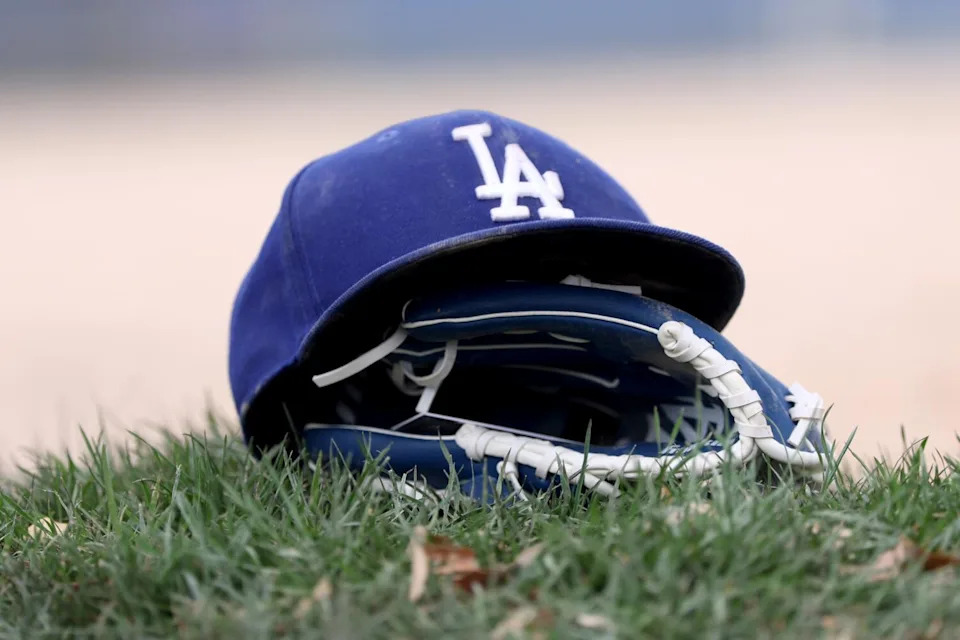 A Dodgers hat and glove rest on grass during Dodgers spring training at Camelback Ranch in Arizona on Monday.