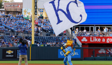 Sep 20, 2025; Kansas City, Missouri, USA; Kansas City Royals mascot Slugger waves the KC flag prior to the game against the Toronto Blue Jays at Kauffman Stadium. Mandatory Credit: William Purnell-Imagn Images