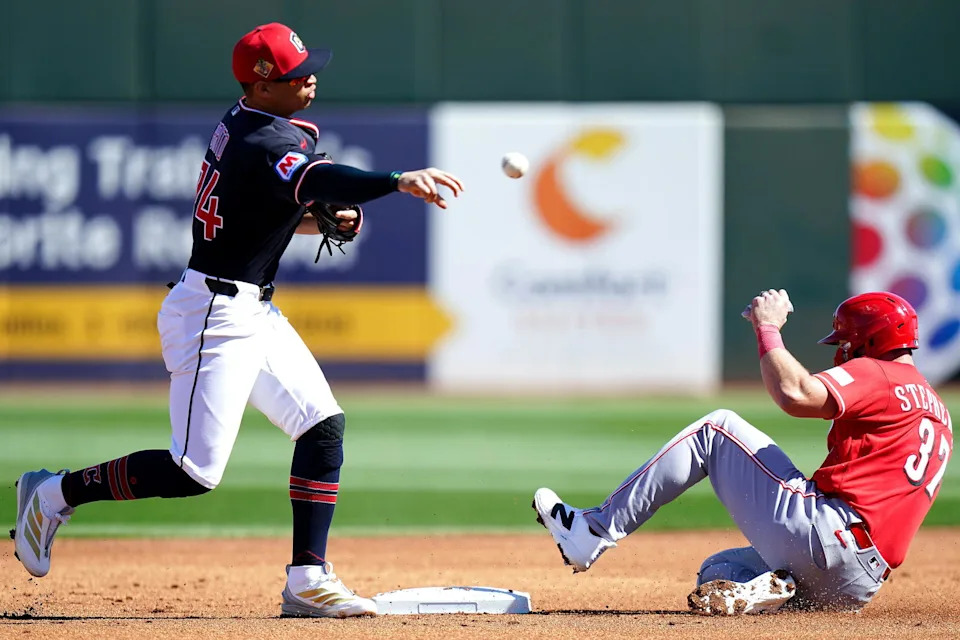 Cleveland Guardians second baseman Juan Brito (74) tags out Cincinnati Reds catcher Tyler Stephenson (37) in the first inning of a Cactus League game between the Cincinnati Reds and Cleveland Guardians, Saturday, Feb. 21, 2026, at Goodyear Ballpark in Goodyear, Ariz.