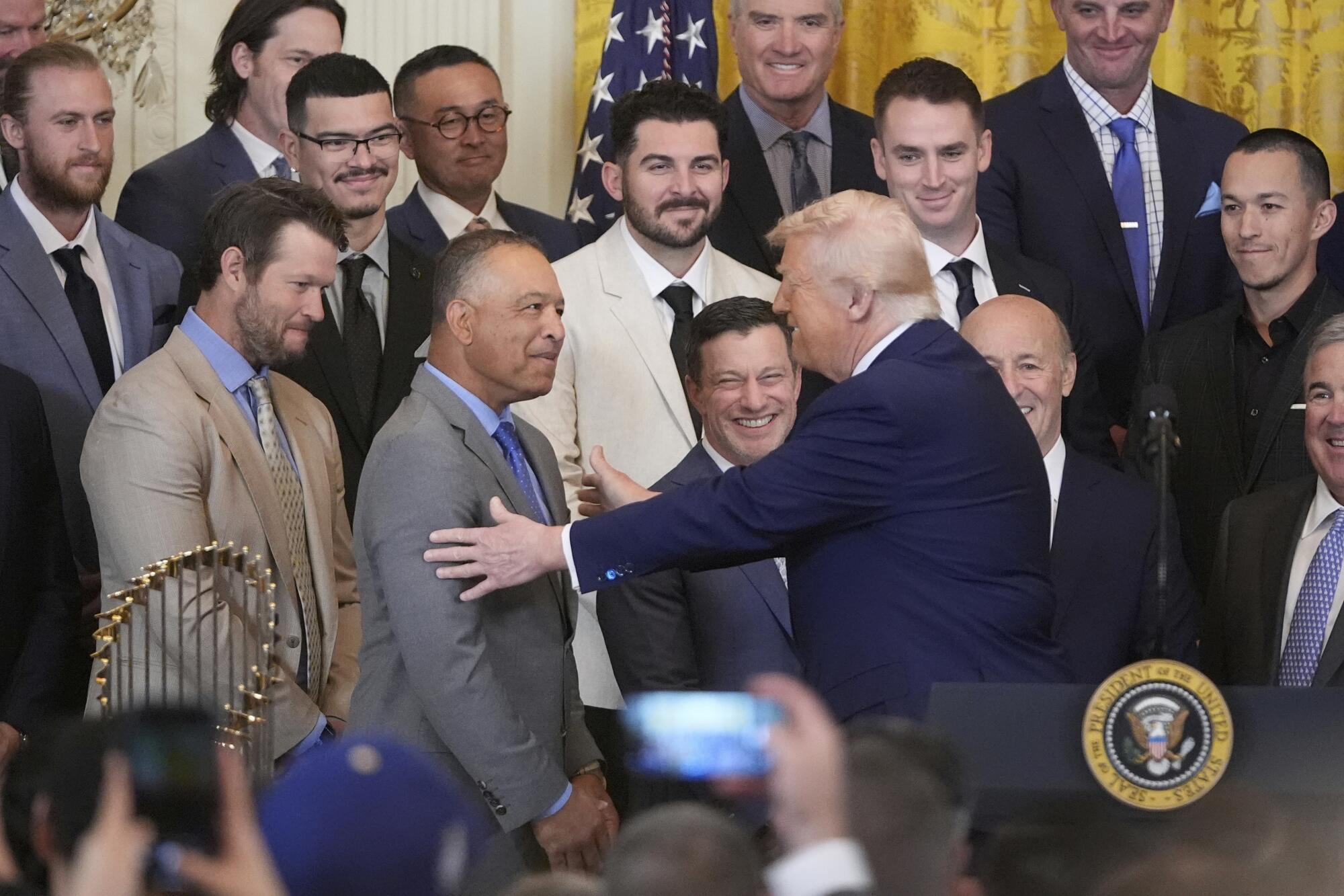 President Donald Trump greets manager Dave Roberts during a ceremony to honor.