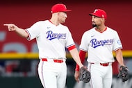 Texas Rangers shortstop Corey Seager (left) talks with second baseman Marcus Semien between...
