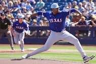 Texas Rangers pitcher Kumar Rocker pitches during the first inning of a spring training game...