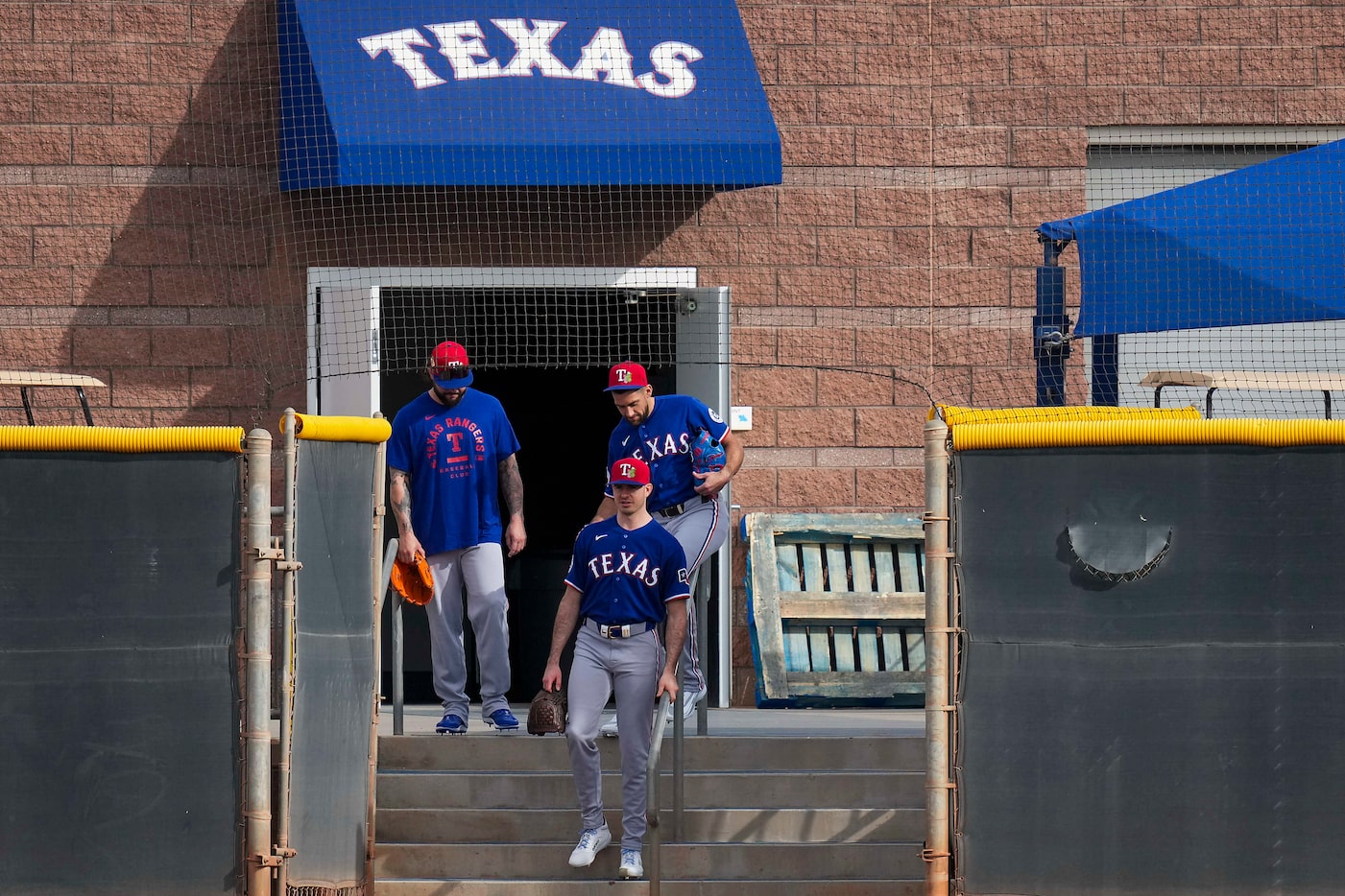 Texas Rangers pitcher Nathan Eovaldi (back right) slides on a stair rail as he leaves the...