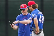 Texas Rangers pitcher Jacob Degrom (48) works with pitching coach Jordan Tiegs during a...