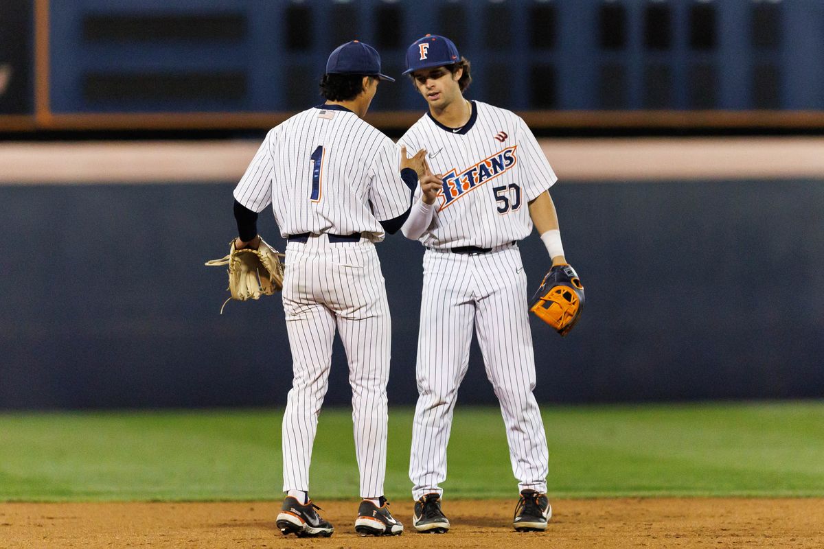 CSUF infielders Eli Lopez (1) and Cade O'Hara (50) shake hands during an NCAA Baseball game against the CBU Lancers on February 13, 2026 in Fullerton, California.
