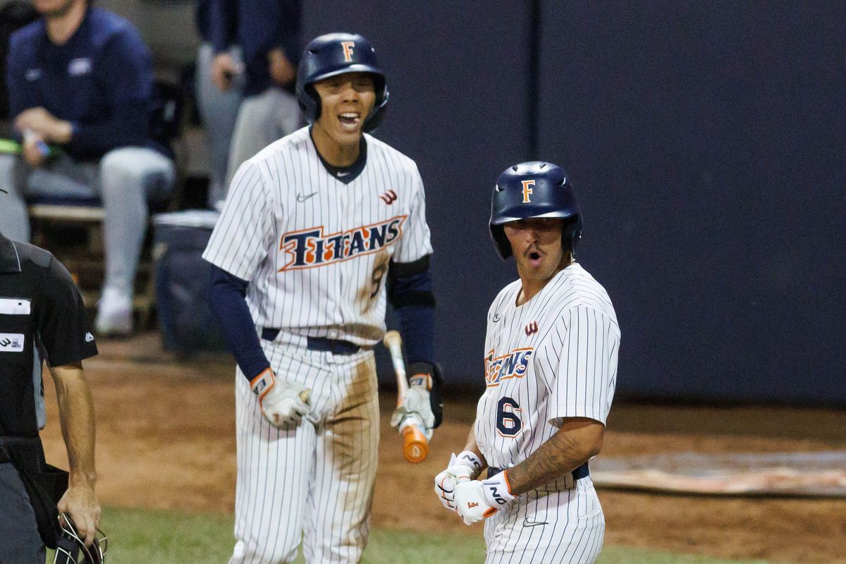 CSUF Titans outfielder Hunter Meyer (6) and infielder Cameron Kim (9) celebrates after scoring a run during an NCAA Baseball game against the CBU Lancers on February 13, 2026 in Fullerton, California.