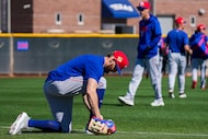 Texas Rangers outfielder Brandon Nimmo ties his cleats during a spring training workout at...