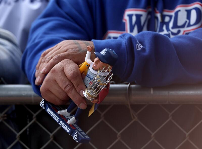 A fan holds a World Series bobblehead while waiting to greet players at Dodgers spring training.