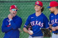 Texas Rangers manager Skip Schumaker (lfrom left) laughs in the bullpen with pitchers Jacob...