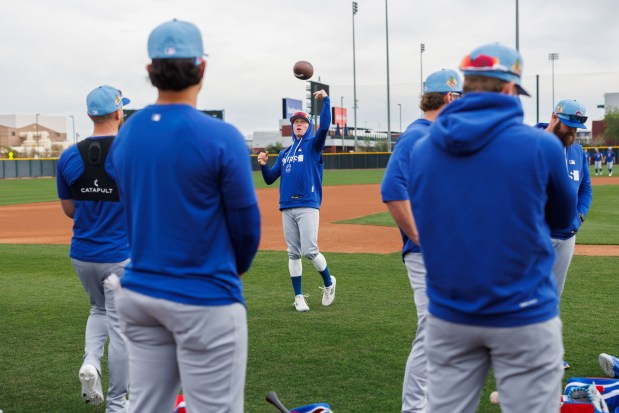 Pete Crow-Armstrong throws a football with other players before warming up during the first day of the Cubs full-squad workout at spring training at Sloan Park on Feb. 16, 2026, in Mesa, Ariz. (Armando L. Sanchez/Chicago Tribune)