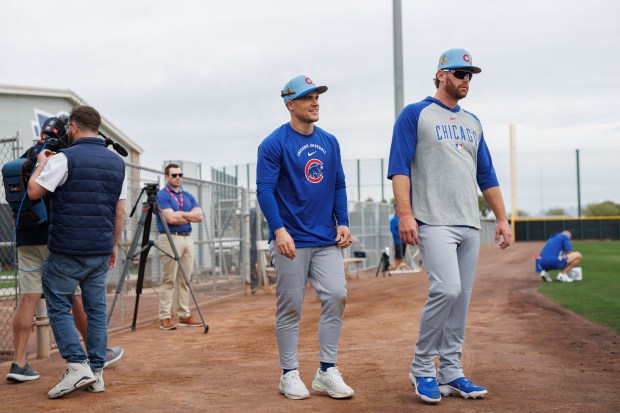 Matt Shaw and catcher Carson Kelly walk on the field during the first day of the Cubs full-squad workout at spring training at Sloan Park on Feb. 16, 2026, in Mesa, Ariz. (Armando L. Sanchez/Chicago Tribune)