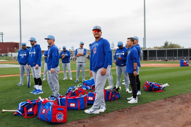 Miguel Amaya, center, stands with other players before warming up during the first day of the Cubs full-squad workout at spring training at Sloan Park on Feb. 16, 2026, in Mesa, Ariz. (Armando L. Sanchez/Chicago Tribune)