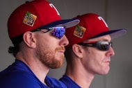 Texas Rangers outfielders Brandon Nimmo (left) and Mark Canha watch from the dugout during...