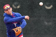 Sam Haggerty makes a throw as rain falls while participating in a fielding drill during...