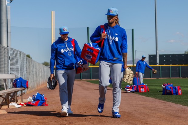 Cubs outfielders Ian Happ, left, and Kevin Alcántara leave a practice field during spring training at Sloan Park on Feb. 19, 2026, in Mesa, Ariz. (Armando L. Sanchez/Chicago Tribune)