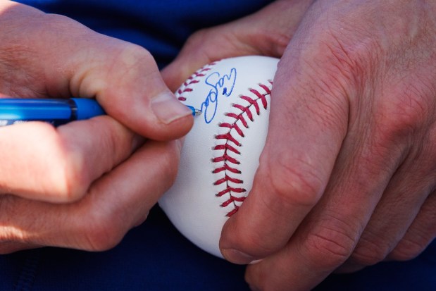 Cubs manager Craig Counsell signs a baseball for Advocate Children's Hospital patients after they signed one-day contracts during spring training at Sloan Park on Feb. 19, 2026, in Mesa, Ariz. (Armando L. Sanchez/Chicago Tribune)