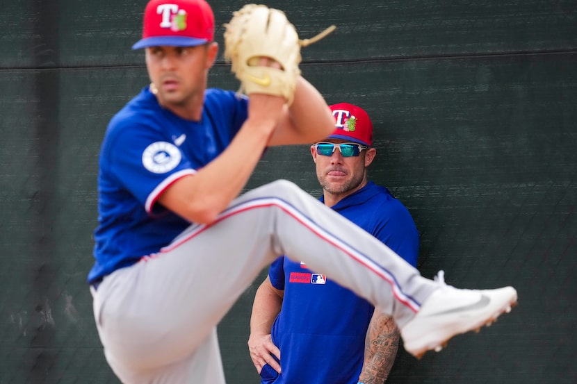 Texas Rangers manager Skip Schumaker watches pitcher MacKenzie Gore throw in the bullpen...
