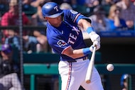 Texas Rangers third baseman Josh Jung singles during the second inning of a spring training...