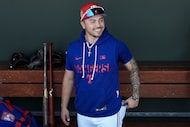 Texas Rangers infielder Cody Freeman looks out from the dugout before a spring training game...