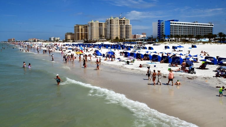 Tourists bustle along Clearwater Beach in Florida.