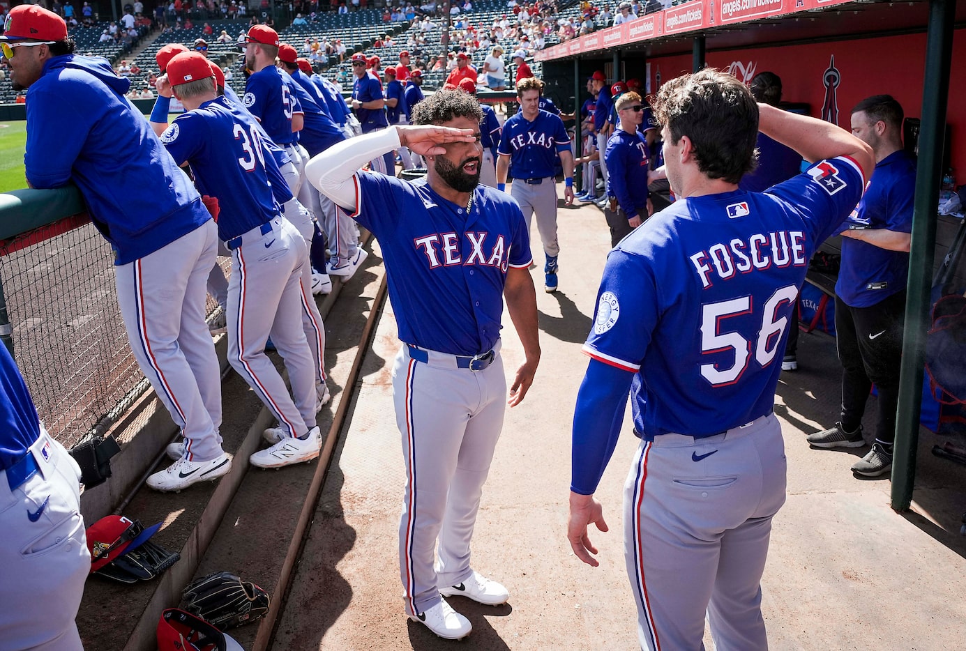 Texas Rangers infielder Ezequiel Duran salutes infielder Justin Foscue in the dugout before...